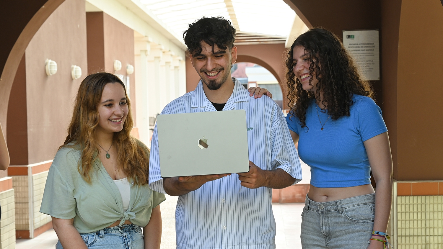 Estudiantes compartiendo una computadora en un corredor de la Universidad de Porto